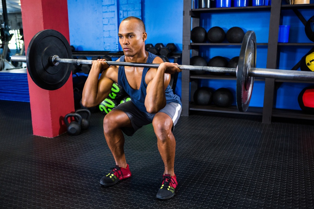 Full length of male athlete weightlifting in fitness studio.jpeg