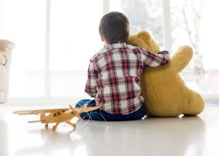 Portrait of child sitting in living room with Teddy bear.jpeg