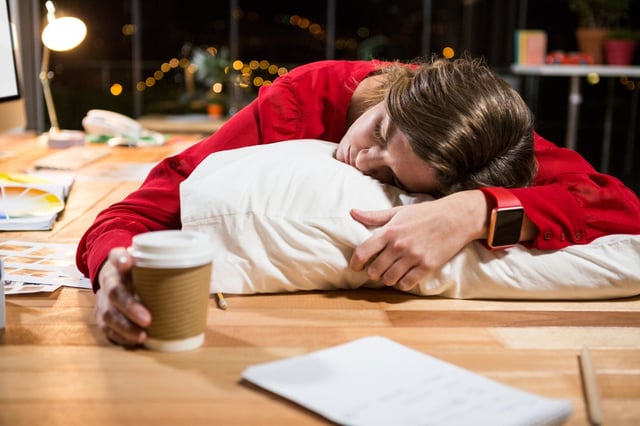 Tired businesswoman sleeping on the desk in the office.jpeg