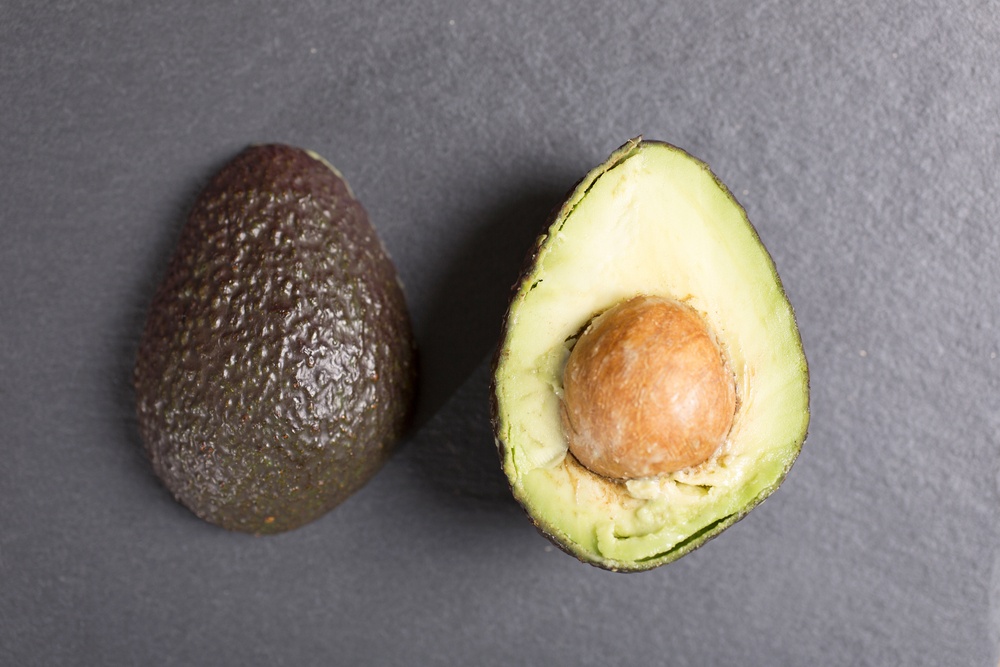 Exotic fresh avocado on black slate with copy space